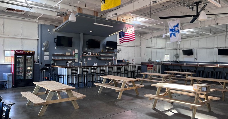 Interior, bar area and seating with wooden picnic tables and benches