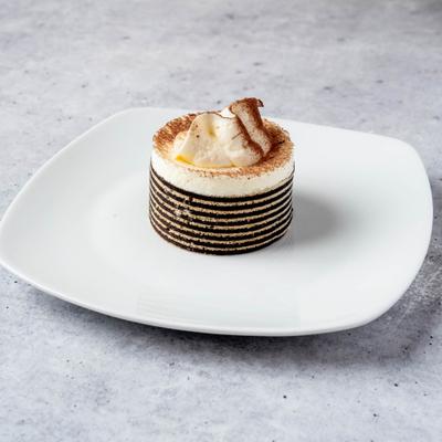 Mini layered dessert presented on a white square plate.