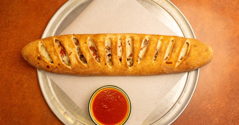A stromboli sandwich with sauce on the side