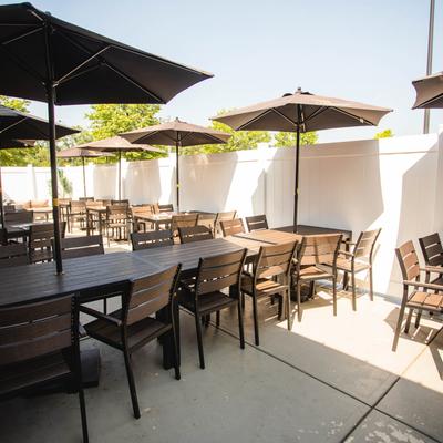 Outdoor seating area with tables and ubmrellas.