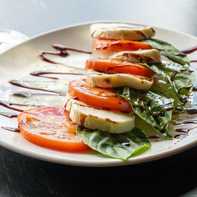 Caprese Salad with tomatoes, mozzarella, basil, and balsamic glaze.