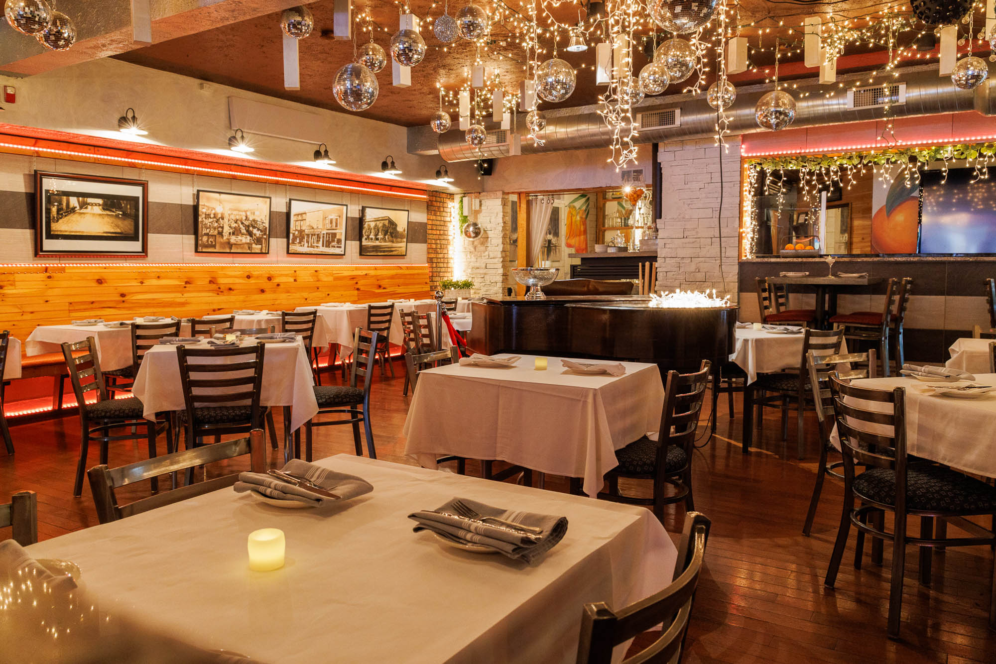 Elegant restaurant with white tablecloths, fairy lights, and small disco balls