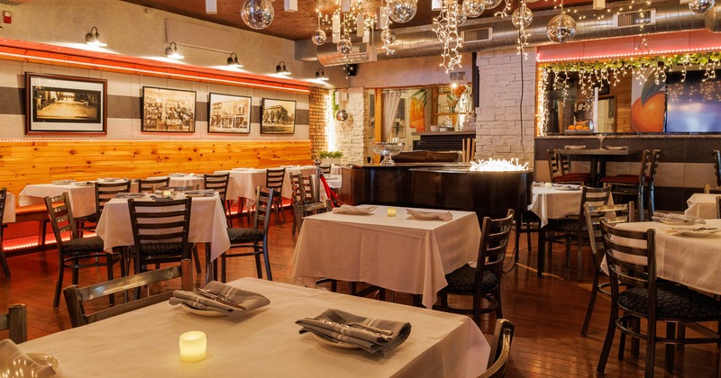 Interior, dining area, white cloth tables with chairs, stage piano in the middle of the room