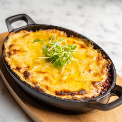 Layers of potatoes, eggplant, and ground beef topped with bechamel sauce.