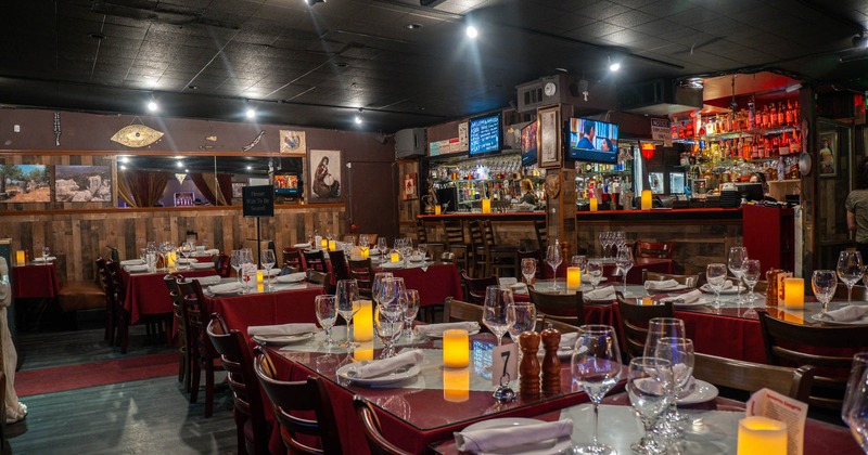 Interior, dining area, tables for four and eight, ready for guests, bar in the back