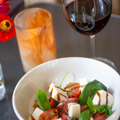 A served salad with a drink.