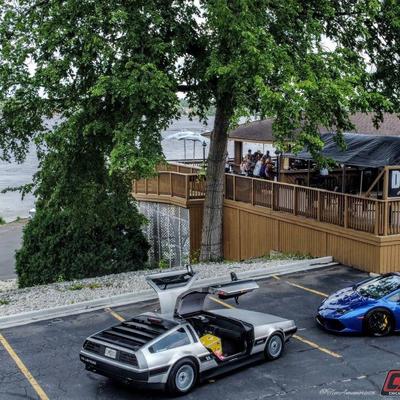 Cars parked in front of the restaurant, trees.