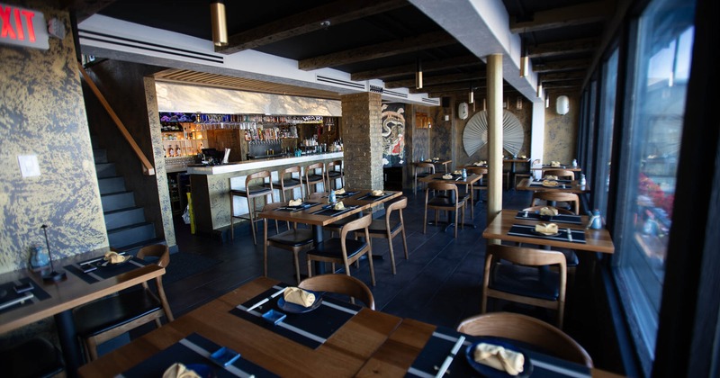 Interior, dining area, tables with chairs ready for guests, tile flooring, bar in the back