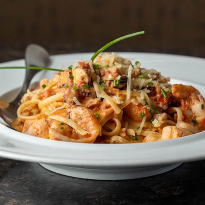 Creamy seafood pasta topped with shredded cheese and fresh chives.