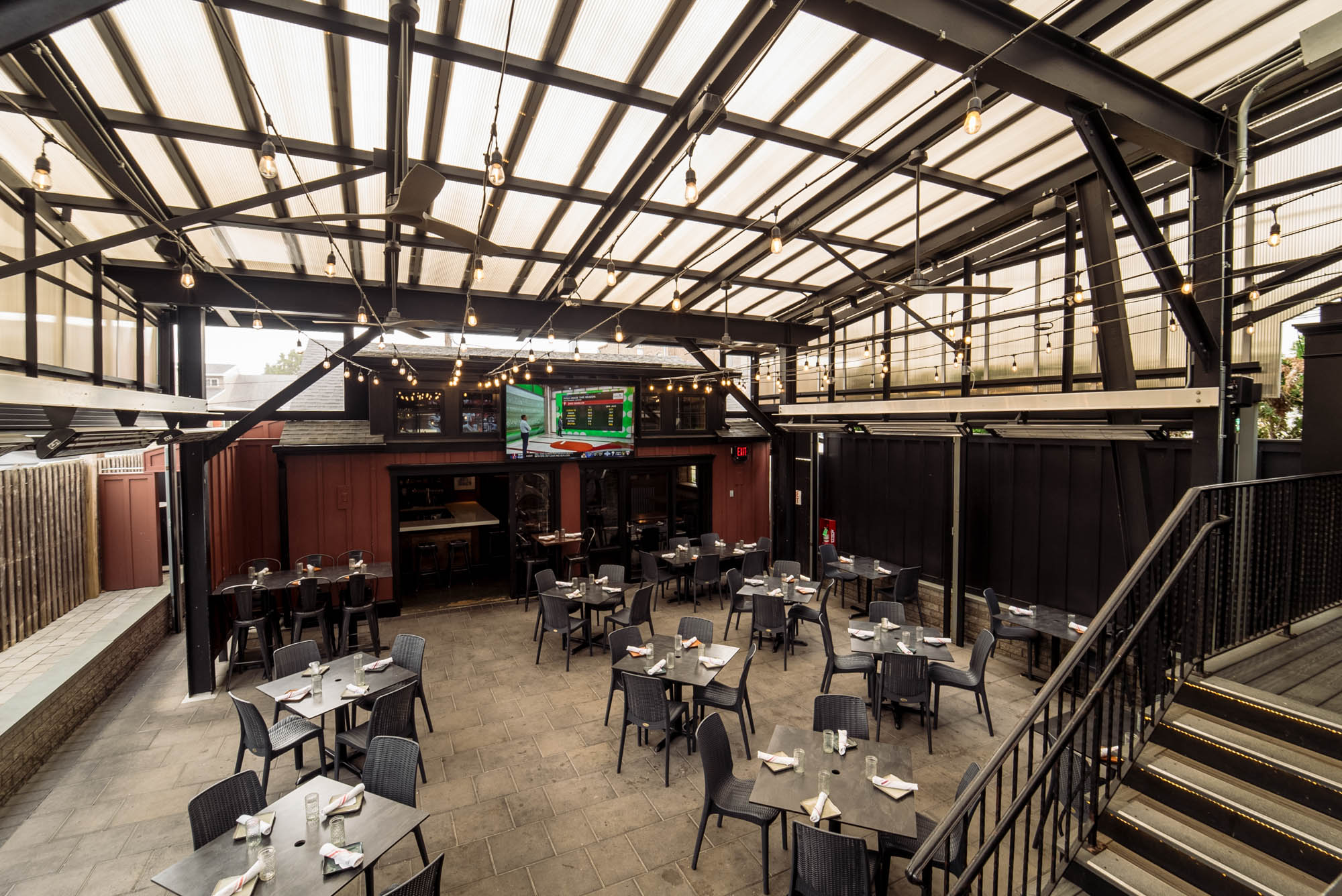 Interior with a glass ceiling, set tables, and string lights