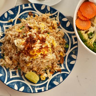 Crab fried rice with small bowl of vegetables on the side.