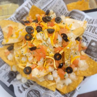 Seafood Nachos, with shrimp, scallops, cheese, tomato, and black olives.