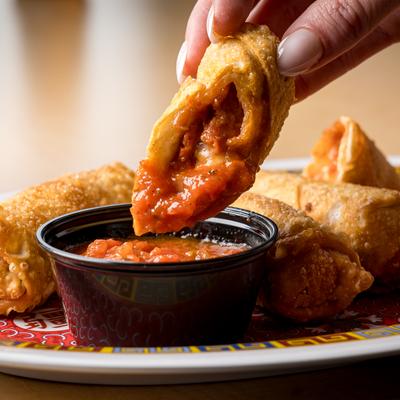 Pizza Rolls being dipped in marinara.