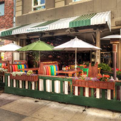 Outdoor seating area of Barney's Beanery with colorful booths and umbrellas