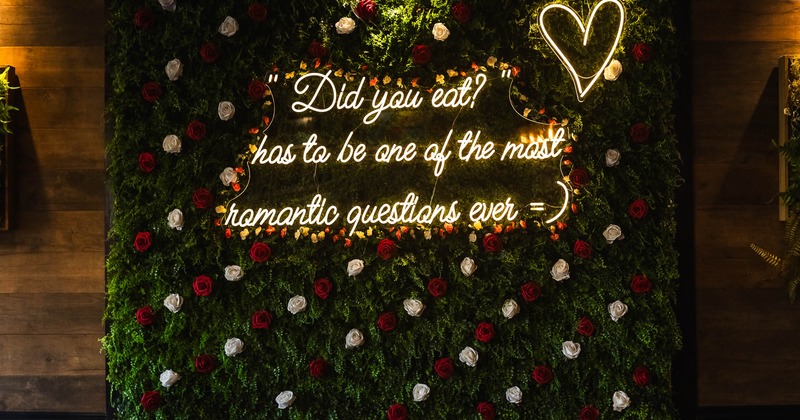 Floral wall with neon light writing