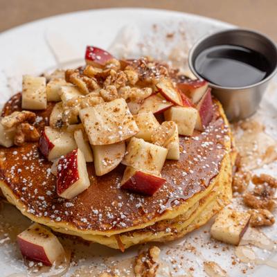 Apple Walnut Pancakes served with syrup on the side.