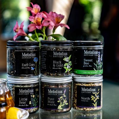 Various loose-leaf tea blends in small jars.