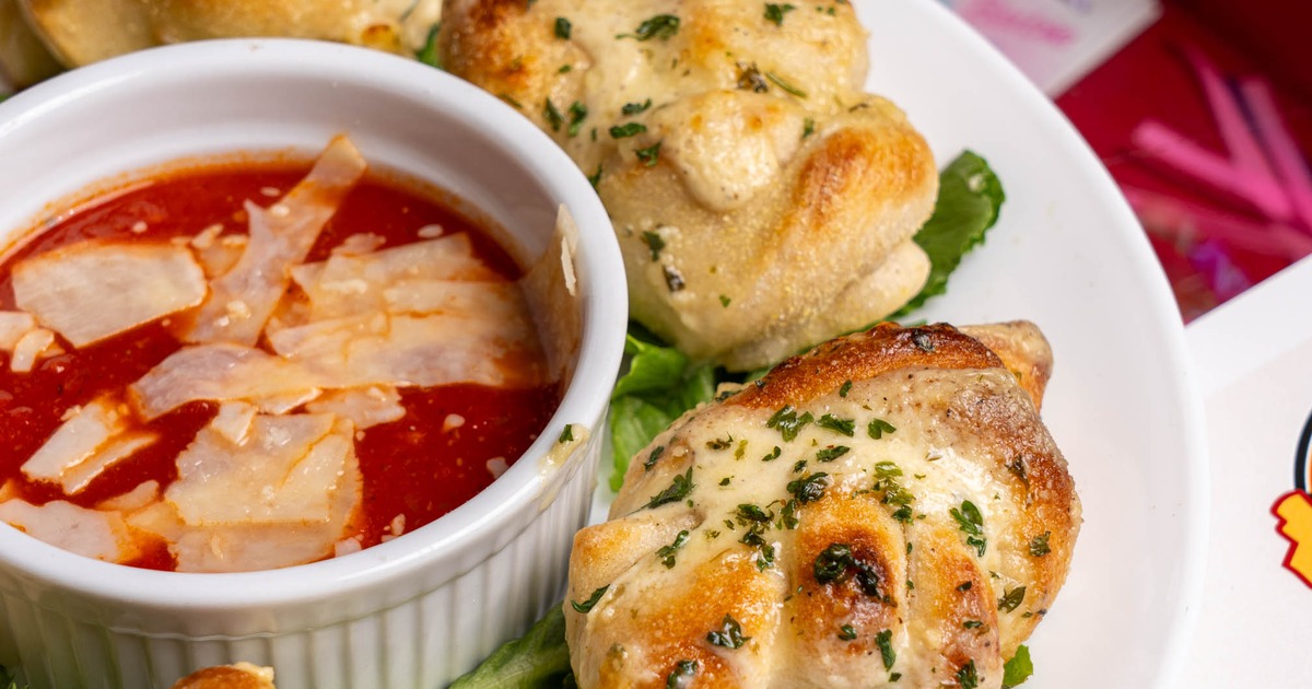 Garlic naughty knots served around a ramekin containing marinara sauce