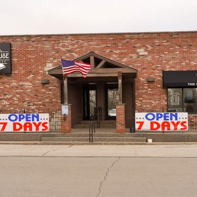 Restaurant's exterior with signage, entrance and American flag.