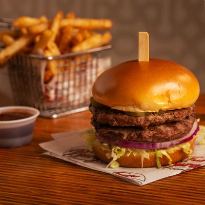 Double burger served with fries and barbecue sauce.