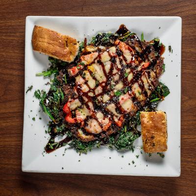 Eggplant with melted cheese and balsamic, served over sauteed spinach with toasted bread.
