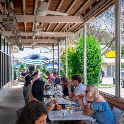 Exterior, guests dining in the patio seating area