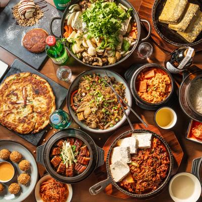 Assortment of dishes served on the table with drinks and condiments, overhead view.