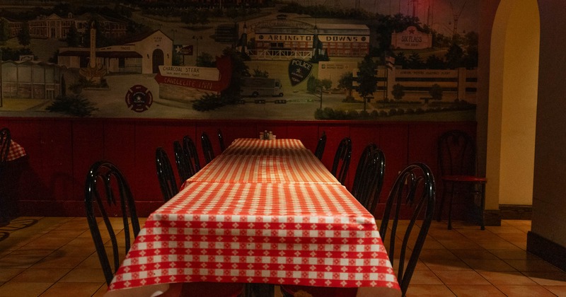 Interior, lined tables with painted on the wall in the back