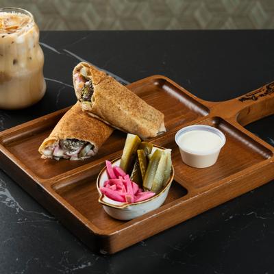 Crispy falafel sandwich served with pickled veggies, yoghurt-based sauce, and iced coffee.