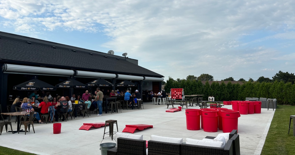 Guests sitting under parasols on a patio with oversized games