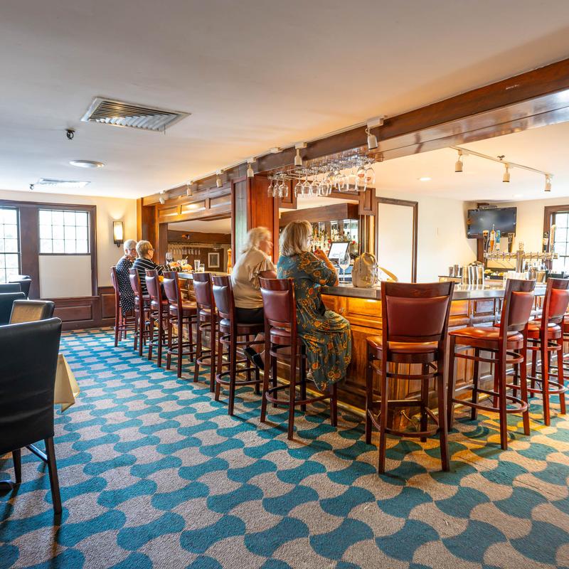 Restaurant bar area with counter seating and dining tables