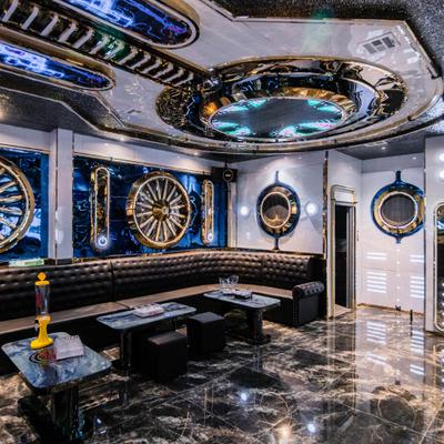 Lounge with black seating, metallic decor, and glossy floor.