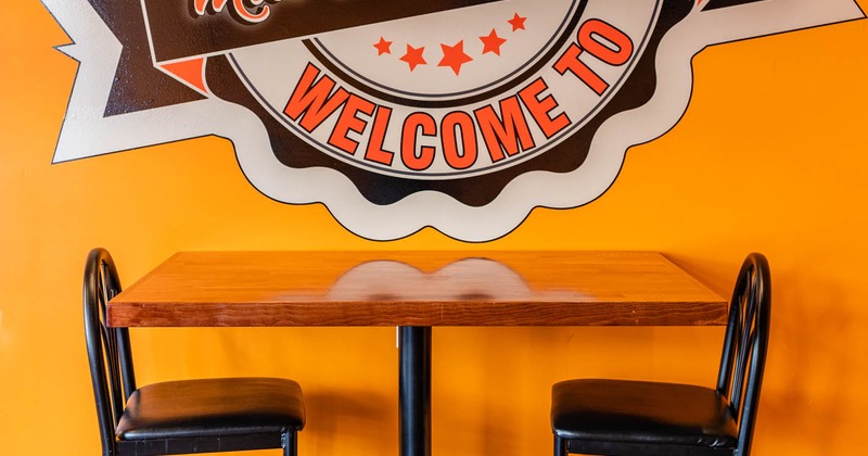 Table for two by a wall with Miss Carter's Place logo, closeup