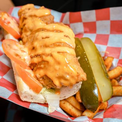 Catfish Po'boy served with fries and pickle spears.