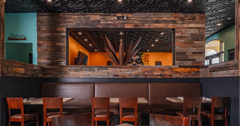Restaurant interior with wooden tables and chairs, brown leather booth