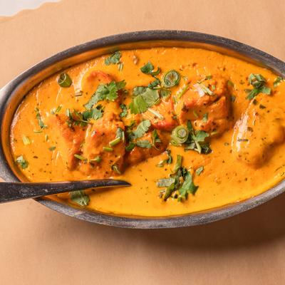 Chicken Tikka Masala served in an oval metal dish, overhead view.