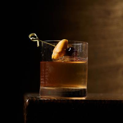Classic Old Fashioned, garnished with a citrus peel and cherry.