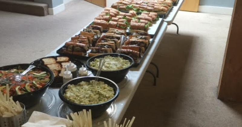 Buffet table with sandwiches, pasta salads, and sauces