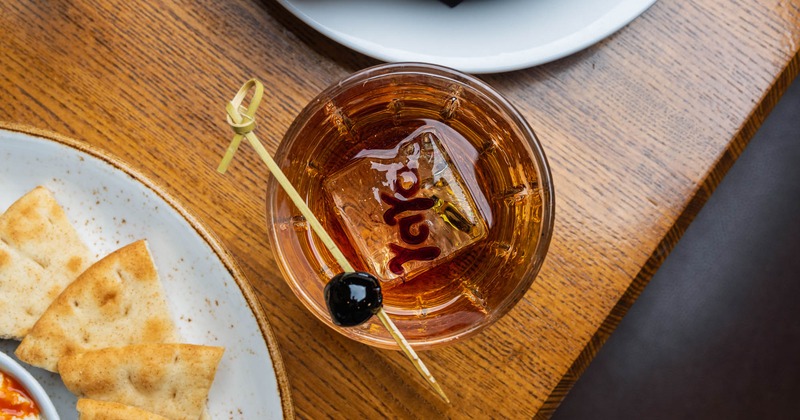 Old Fashioned glass featuring cherry garnish and a large YaYa ice cube, top view