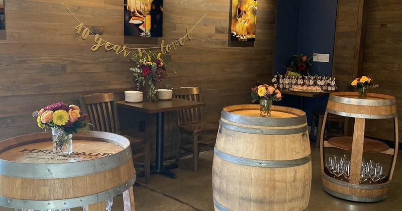 Interior, decorative barrels, flowers, table, chairs, art on the wall