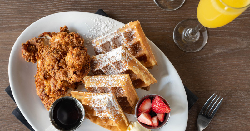 Fried chicken and waffles, dressing dip and fresh strawberries, top view