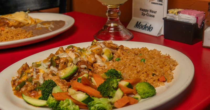 Mexican chicken platter with rice, cheese, and steamed vegetables