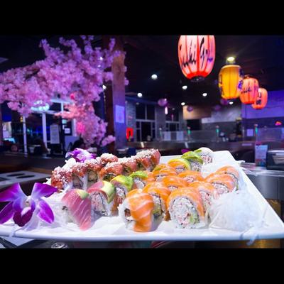 An assortment of sushi rolls served on a white platter in the restaurant setting.