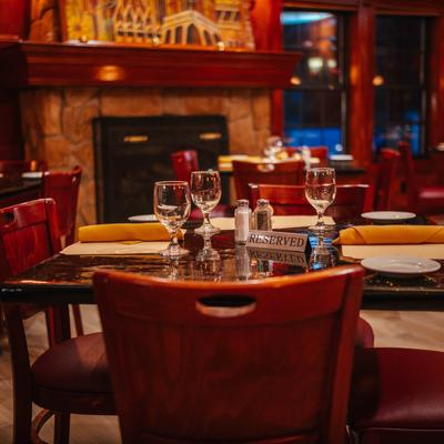 Set dining tables in a room with a fireplace.