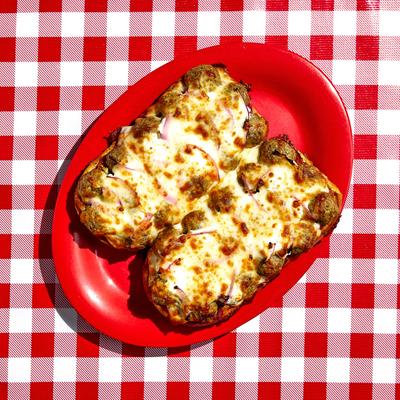 Toasted cheesy sandwich halves on a red plate.