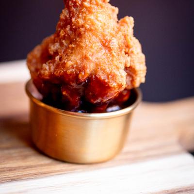 Fried chicken dipped in sauce.