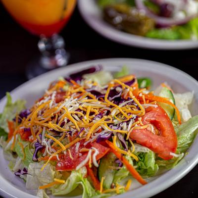 Mixed lettuce and vegetable salad topped with cheese