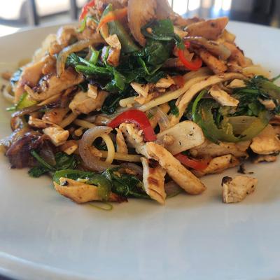 Chicken stir fry with, noodles, peppers, spinach and onions.