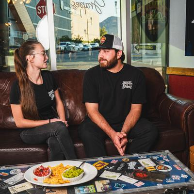 Patrons sitting on a sofa and conversing.