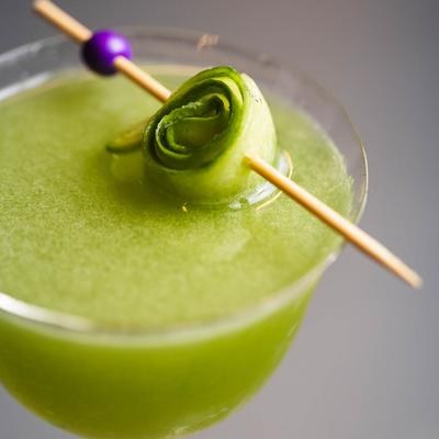 Green cocktail served in a martini glass, close up.